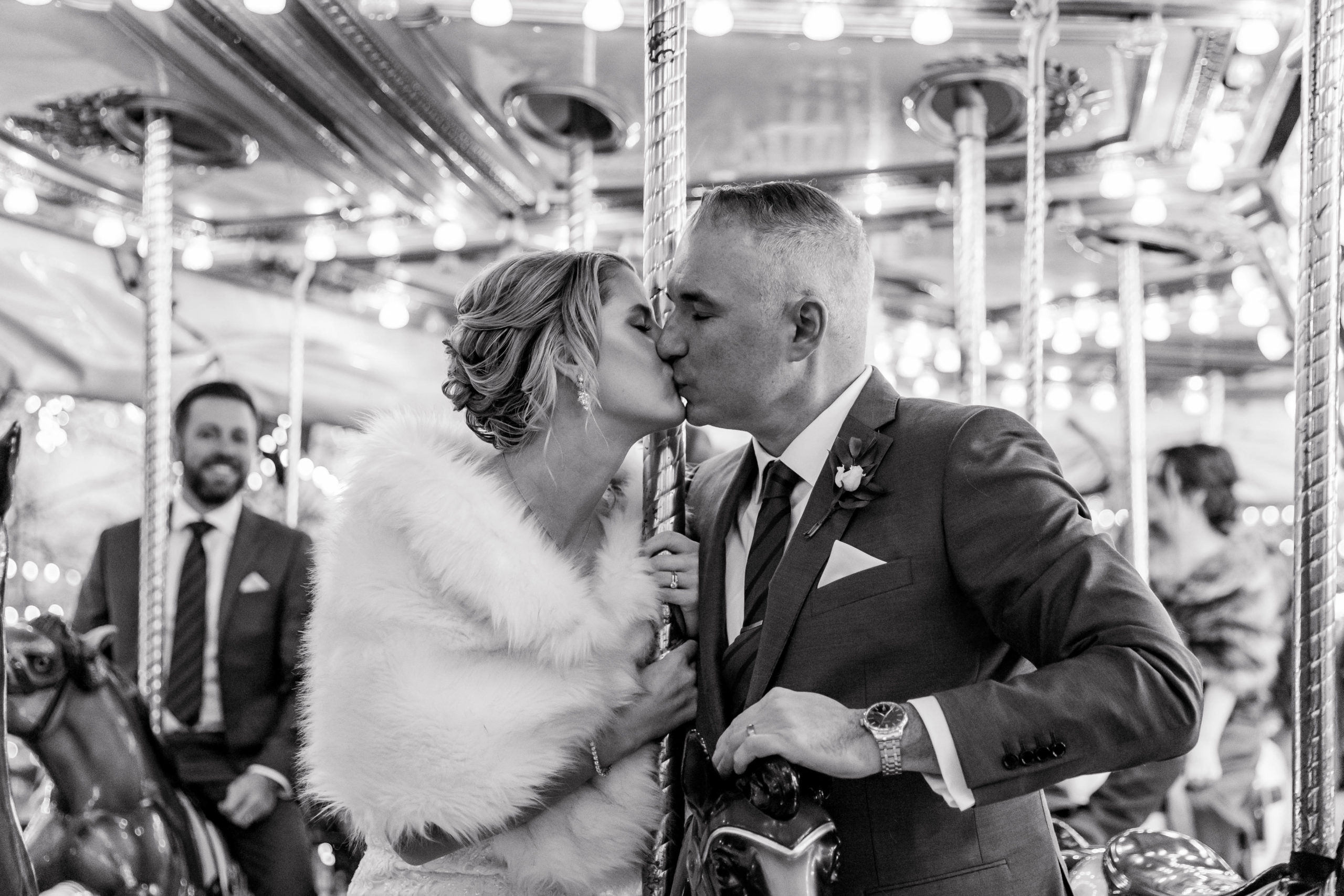 bride and groom kissing at franklin square in philadelphia on a carousel