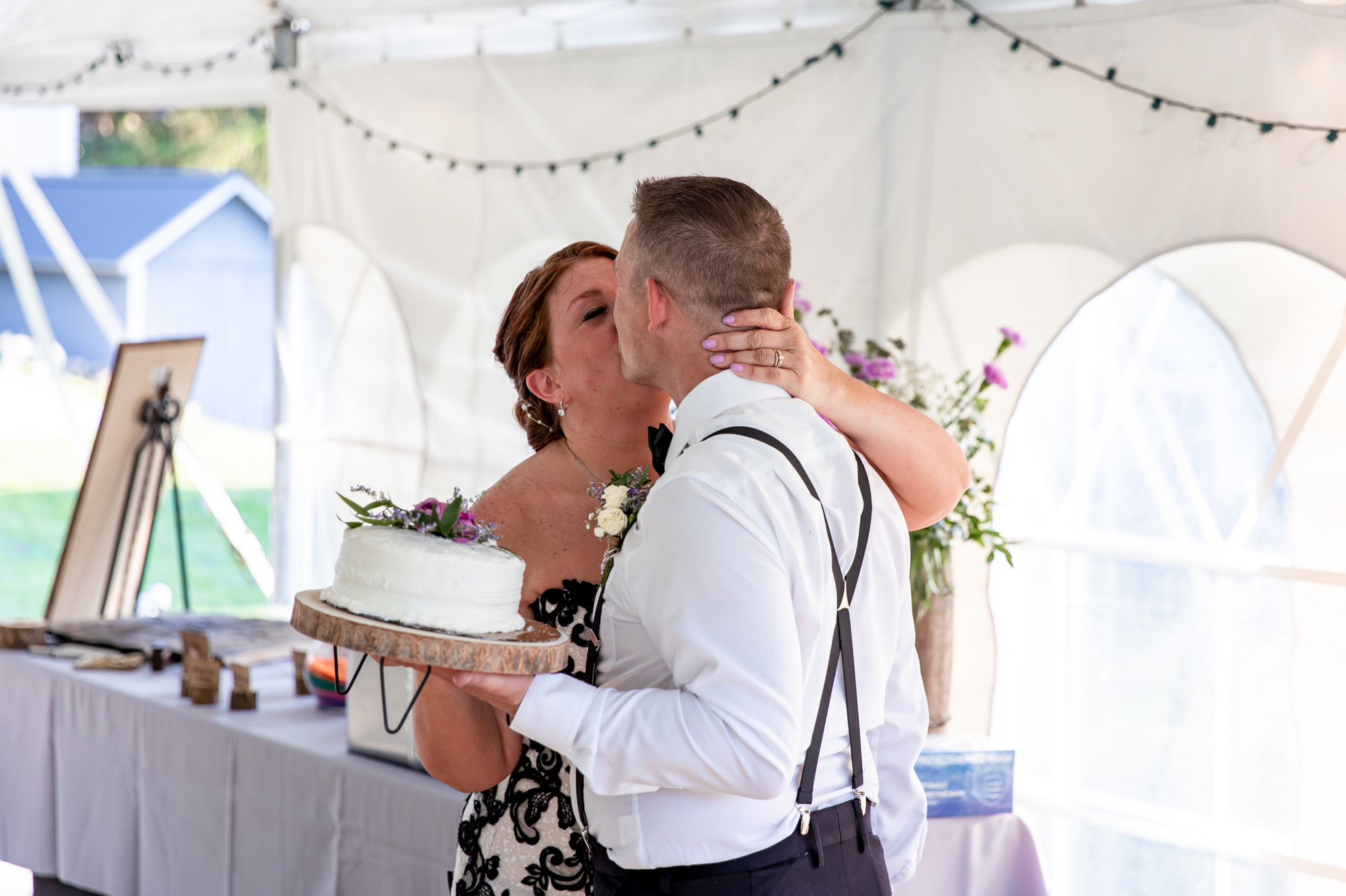 cake cutting at an outdoor tent reception