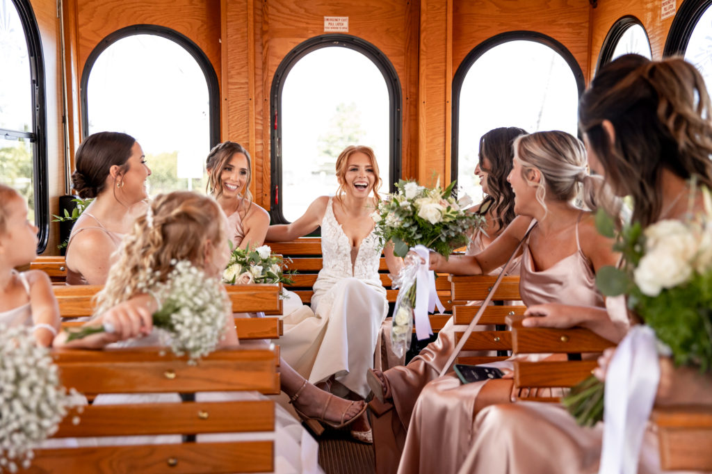 bride laughing with bridesmaids in a trolly on the way to her wedding