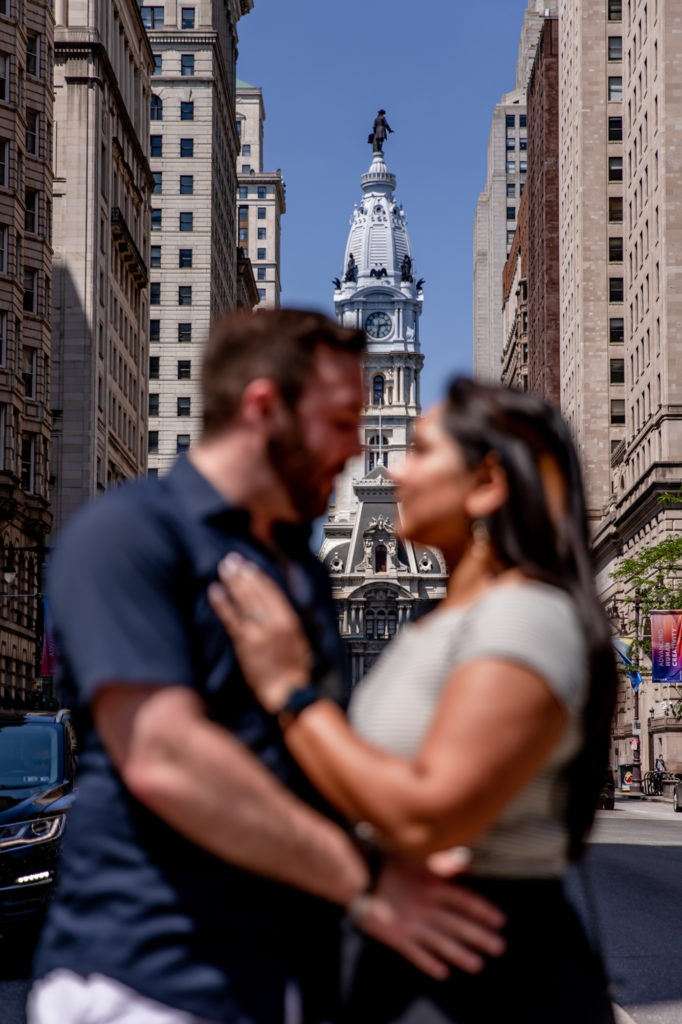 a newly engaged couple in front of city hall