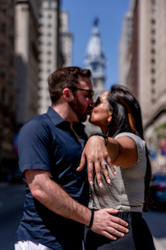 a newly engaged couple in front of city hall