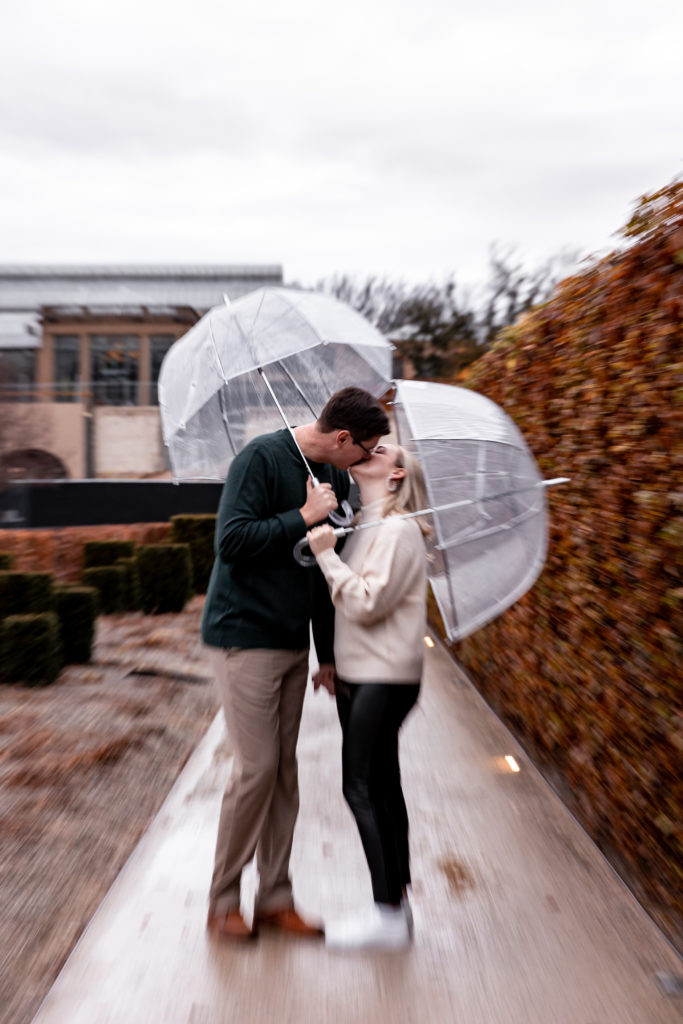 engagement photos with clear umbrellas at longwood gardens during christmastime