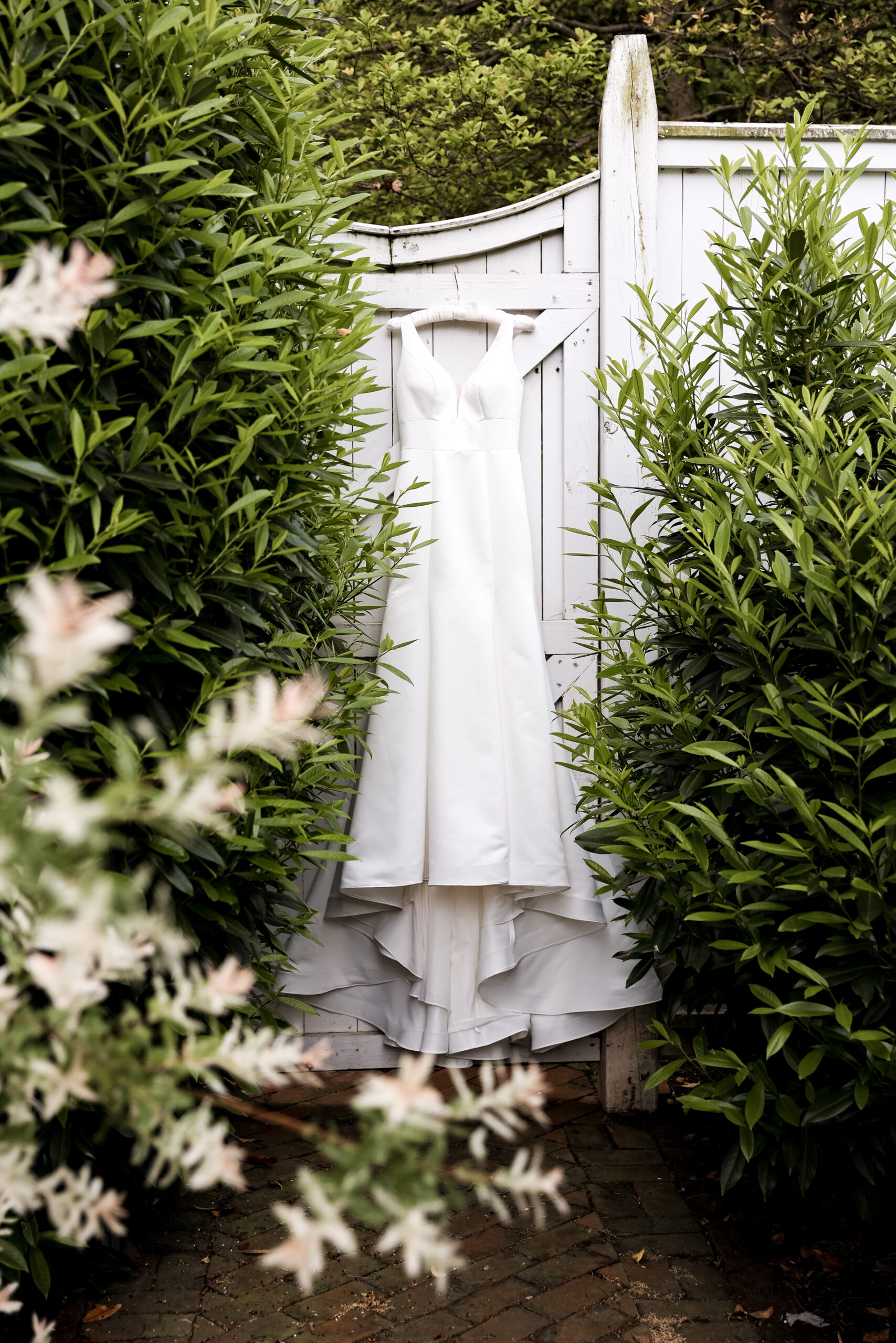 wedding dress hanging on a fence at white chimneys estate wedding venue
