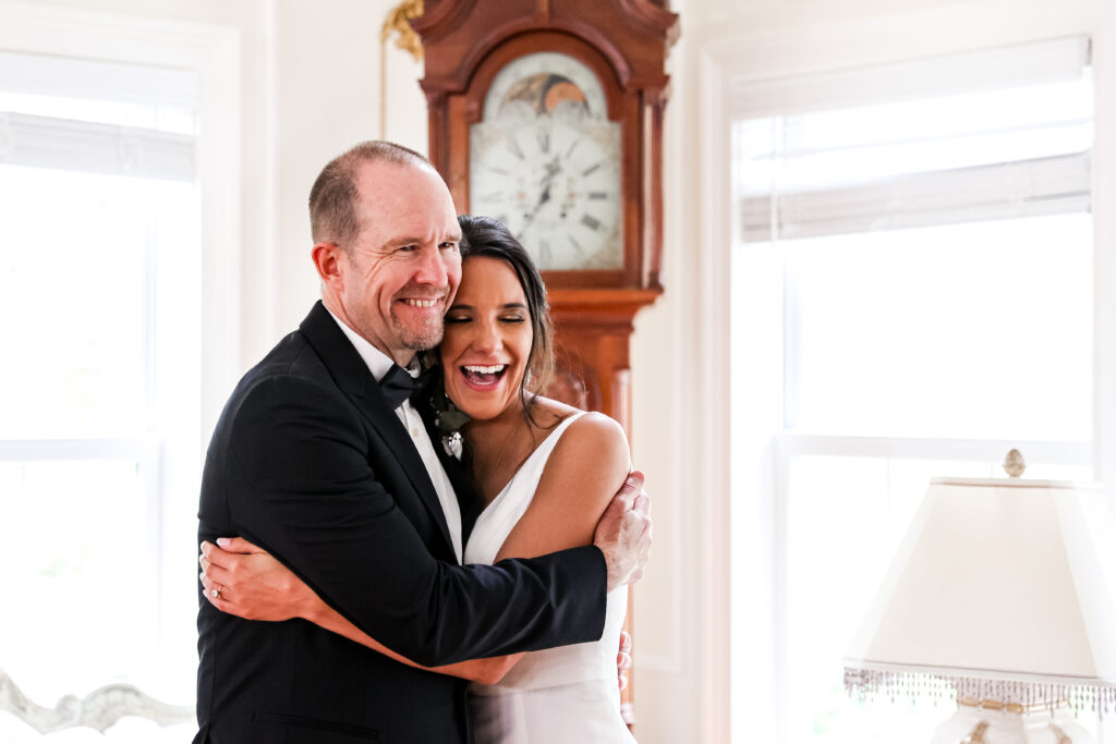 bride shares first look with her father in the bridal suite at white chimneys estate wedding venue
