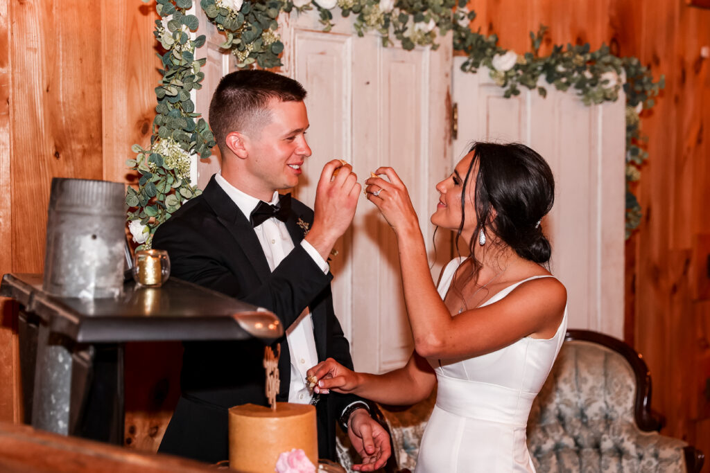cake cutting during a barn reception at a white chimneys estate wedding