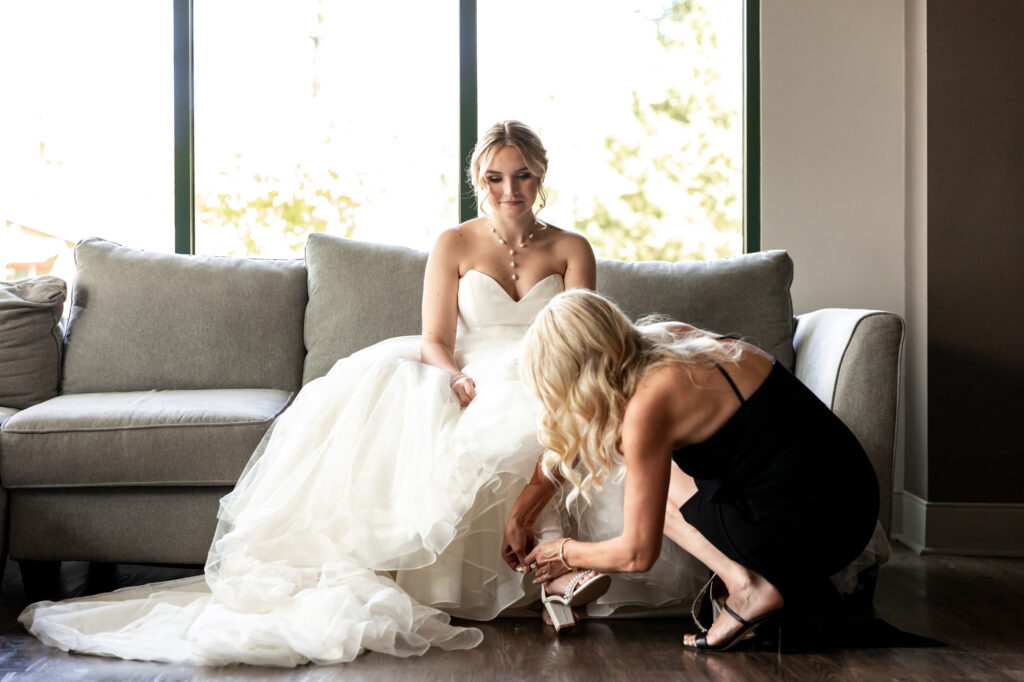 mother helping the bride get dressed