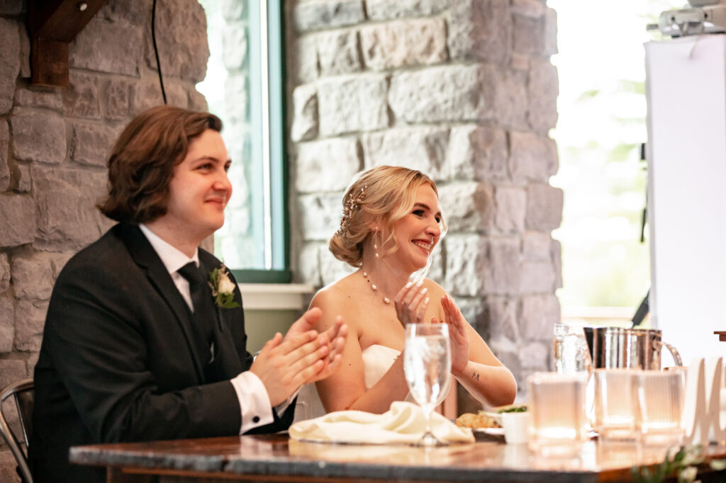 bride and groom reaction to toasts at the wedding reception
