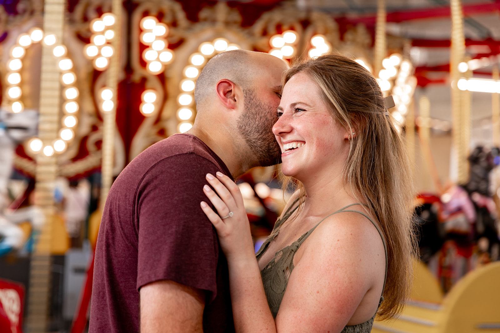 engagement photos in front of a carousel at the boardwalk arcade Funland in Rehoboth Beach, Delaware