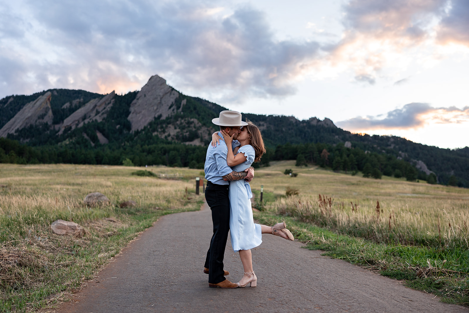 a couple kisses in front of the flat irons during a couples photo session at chautauqua park in boulder, colorado