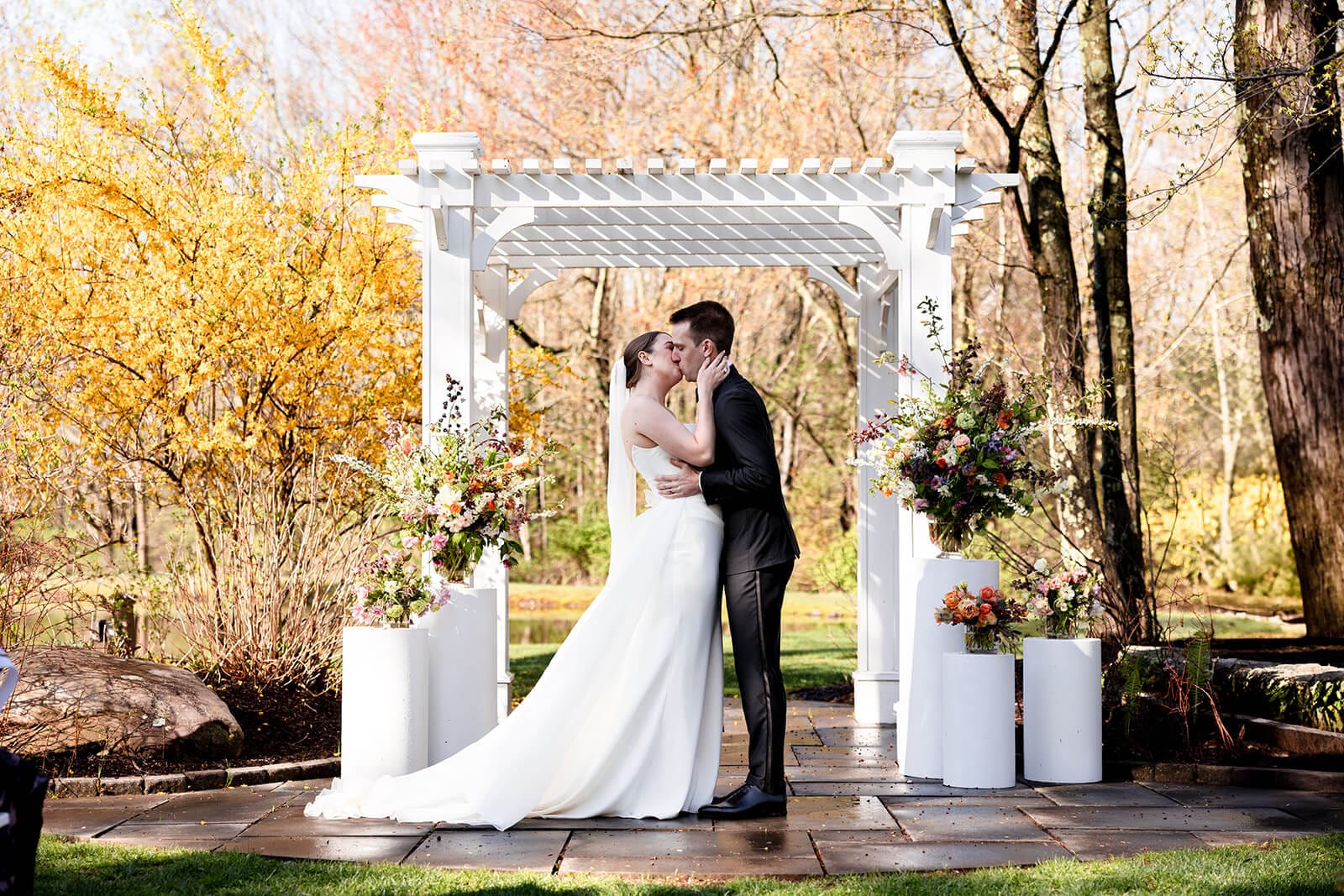 A couple kisses during their outdoor wedding ceremony at Mountain Springs Lake Resort in the Poconos.